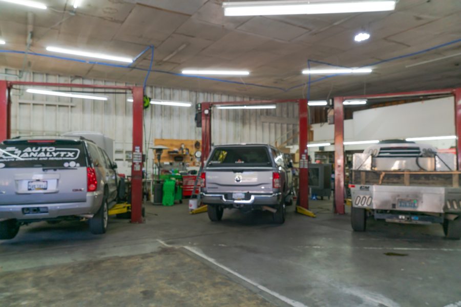 Three service bays with vehicles on two-post lifts inside the Auto Analytx shop in Auburn, CA