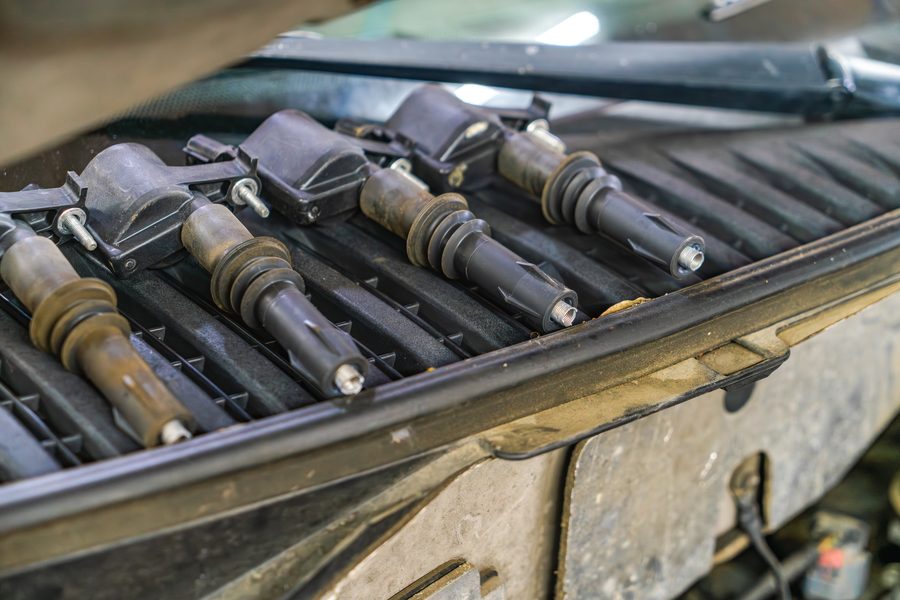 Four ignition coil packs removed from an engine and laid out for testing