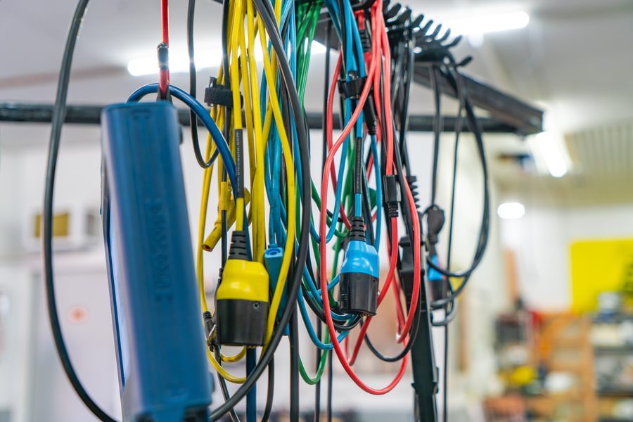 Rack of diagnostic test leads and a current clamp in the Auto Analytx workshop