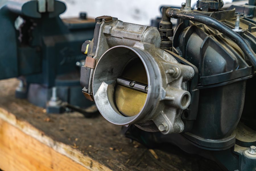 A throttle body removed from an intake manifold on the workbench