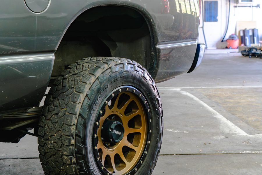 Lifted Dodge Ram on aftermarket wheels and all-terrain tires in the workshop